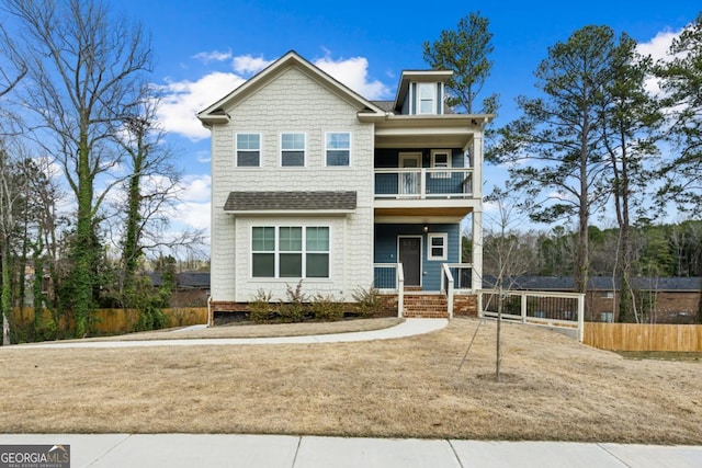 view of front of home with a balcony, covered porch, and fence