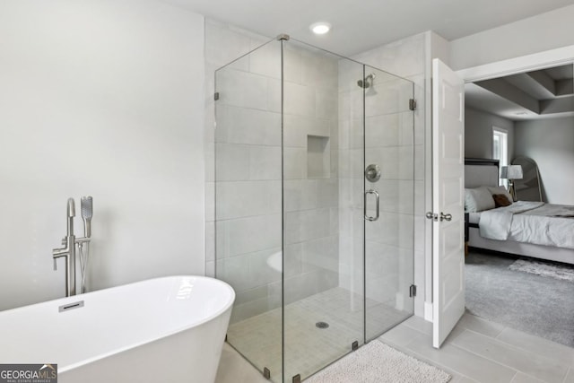 ensuite bathroom featuring tile patterned floors, a soaking tub, a stall shower, and ensuite bathroom