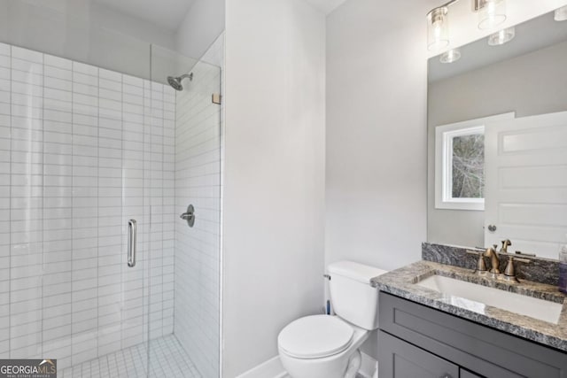 full bath featuring baseboards, vanity, toilet, and a shower stall