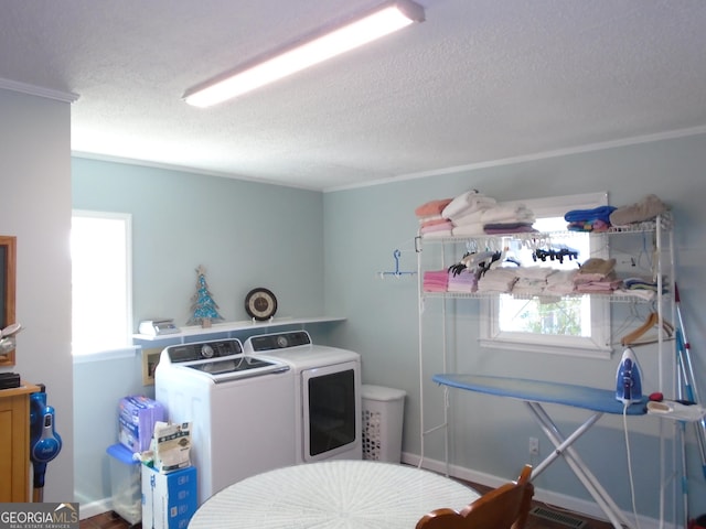 laundry room featuring a textured ceiling, laundry area, baseboards, and washing machine and clothes dryer