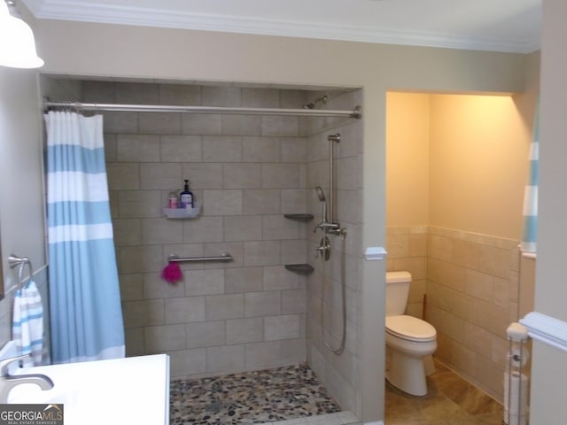 bathroom featuring tile patterned floors, tiled shower, toilet, and ornamental molding