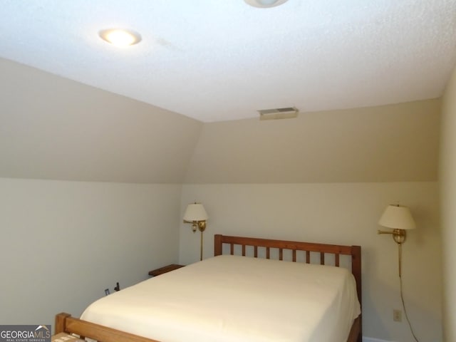 bedroom with lofted ceiling and visible vents