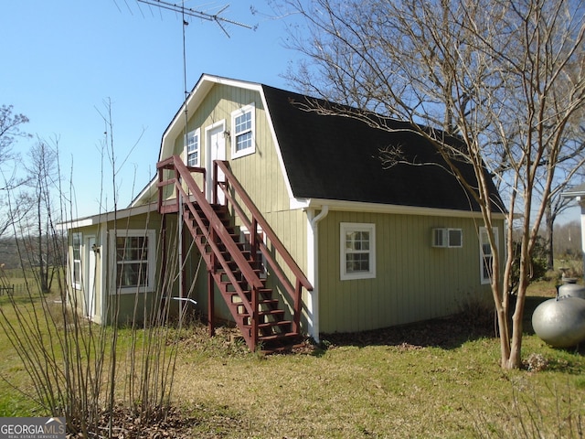 view of property exterior with stairs, a gambrel roof, and a shingled roof