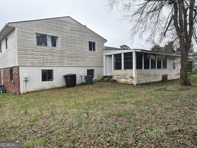 back of house with entry steps, cooling unit, a lawn, and a sunroom