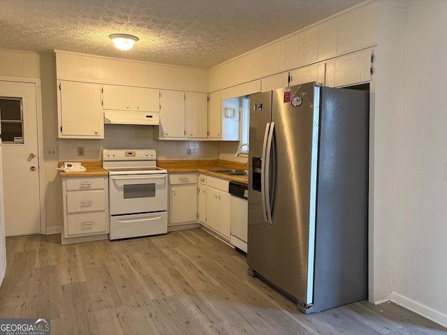 kitchen with under cabinet range hood, a sink, a textured ceiling, white appliances, and light wood finished floors