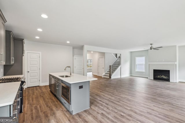 kitchen featuring gray cabinets, appliances with stainless steel finishes, light countertops, and a sink