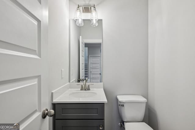 half bath featuring toilet and vanity