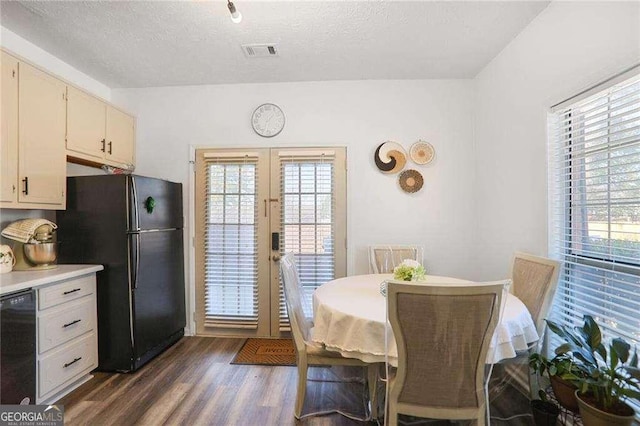 dining space featuring visible vents, a healthy amount of sunlight, dark wood finished floors, and french doors