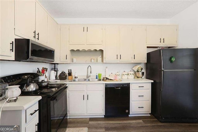 kitchen featuring a textured ceiling, black appliances, light countertops, and a sink