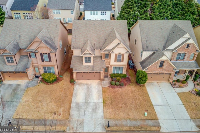 view of front facade with a residential view, an attached garage, and concrete driveway