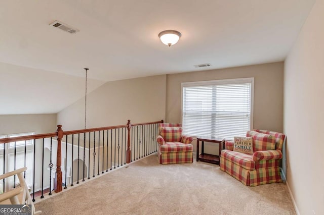 living area featuring visible vents, lofted ceiling, baseboards, and carpet flooring