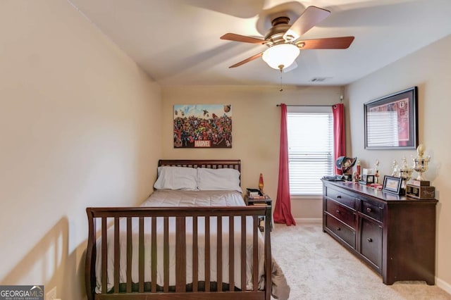 bedroom featuring a ceiling fan, light colored carpet, and baseboards