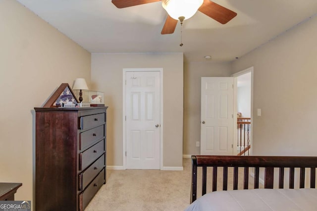 bedroom featuring baseboards, light colored carpet, and a ceiling fan