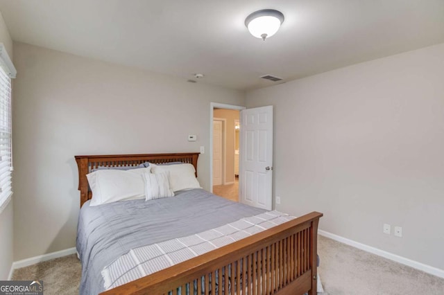 bedroom featuring visible vents, baseboards, and light carpet