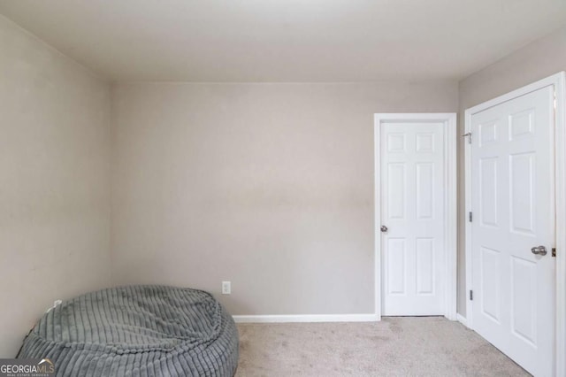 living area with baseboards and light colored carpet