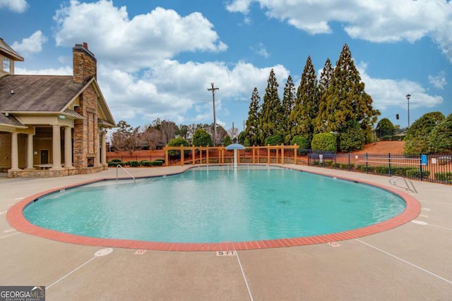 community pool featuring a patio and fence