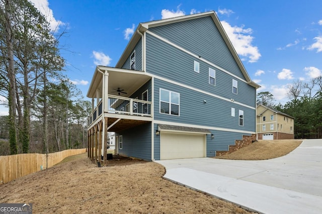 exterior space featuring stairs, an attached garage, concrete driveway, and a ceiling fan