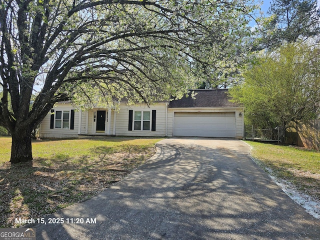 11187 Shannon Cir, Hampton, GA 30228 - view of front of home with a shingled roof, a front lawn, fence, aphalt driveway, and an attached garage