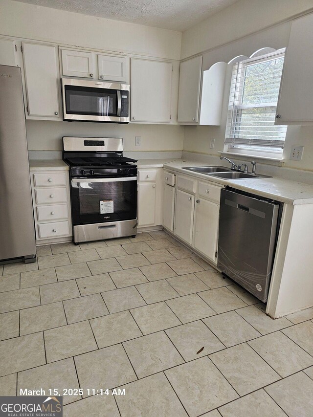 11187 Shannon Cir, Hampton, GA 30228 - kitchen featuring a sink, a textured ceiling, white cabinetry, stainless steel appliances, and light countertops