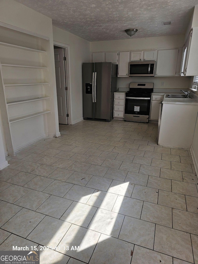 11187 Shannon Cir, Hampton, GA 30228 - kitchen with a sink, a textured ceiling, appliances with stainless steel finishes, white cabinets, and light countertops