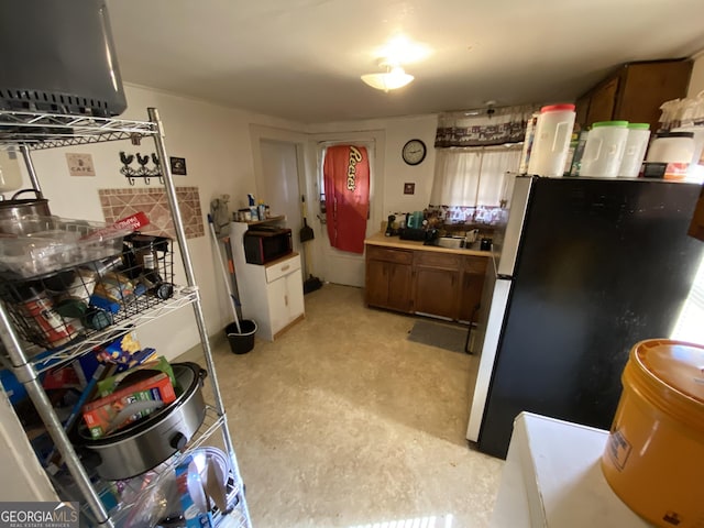 kitchen with freestanding refrigerator, black microwave, and a sink