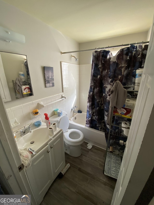 full bathroom with vanity, wood finished floors, shower / tub combo, tile walls, and toilet