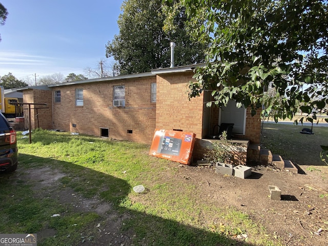 view of side of property featuring brick siding and crawl space