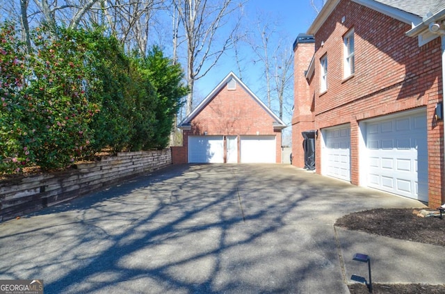 view of property exterior with brick siding and a garage