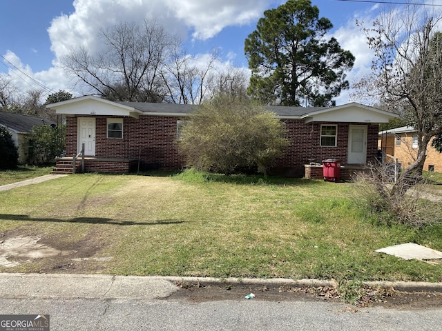 view of front facade featuring brick siding and a front yard