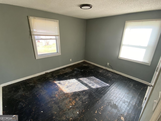 unfurnished room featuring baseboards and a textured ceiling