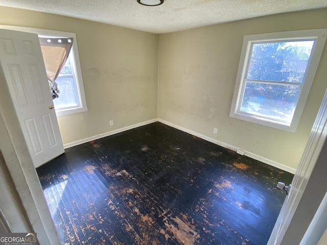 entrance foyer with baseboards, a textured ceiling, and wood finished floors