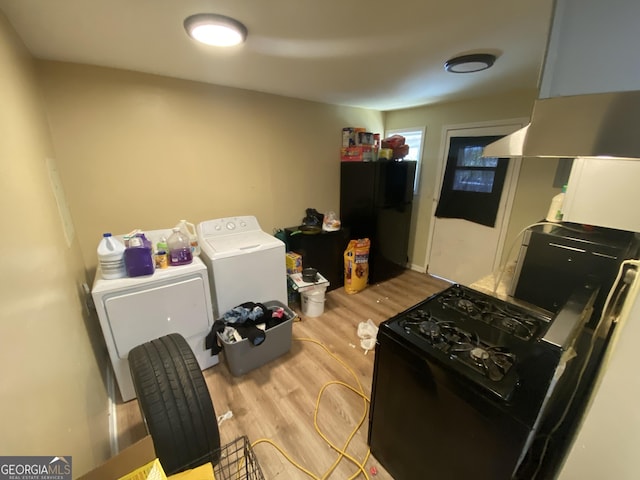 kitchen featuring range hood, black appliances, independent washer and dryer, and light wood-style floors