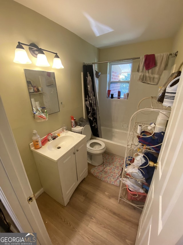 full bath featuring toilet, wood finished floors, vanity, and shower / bath combination with curtain