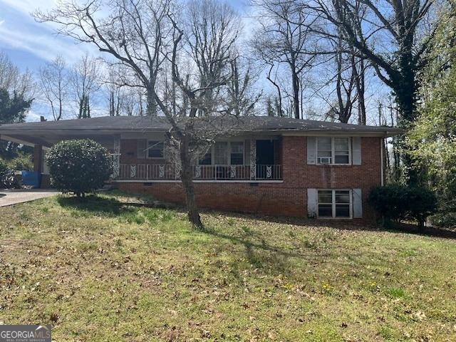 ranch-style home with a front lawn, a porch, a carport, concrete driveway, and brick siding