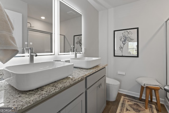 227 Ivey Ter Unit 36, Temple, GA 30179 - full bathroom featuring wood finished floors, baseboards, double vanity, toilet, and a shower with shower door