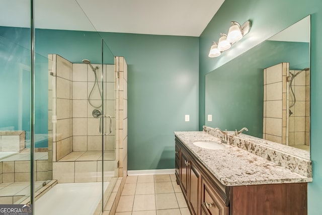 bathroom with baseboards, vanity, tile patterned floors, and a stall shower