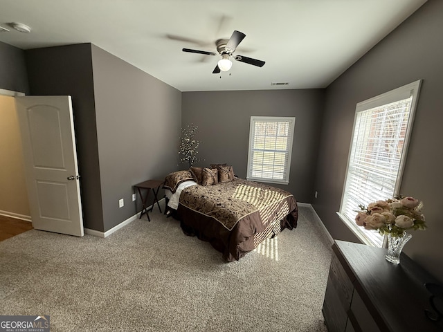 carpeted bedroom with ceiling fan, baseboards, and visible vents