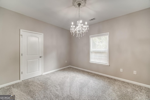 empty room featuring an inviting chandelier, carpet flooring, visible vents, and baseboards