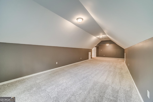 additional living space featuring lofted ceiling, baseboards, and carpet