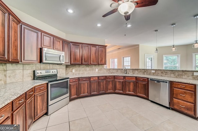 kitchen featuring a ceiling fan, light stone counters, a sink, backsplash, and appliances with stainless steel finishes