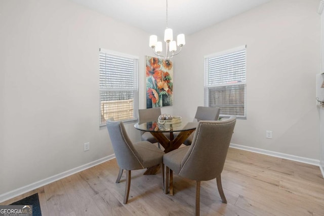 dining space featuring wood finished floors, an inviting chandelier, and baseboards