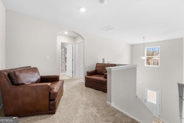 living area with baseboards, light colored carpet, an upstairs landing, recessed lighting, and arched walkways