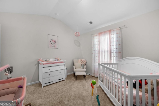 bedroom featuring lofted ceiling, a nursery area, visible vents, and carpet floors