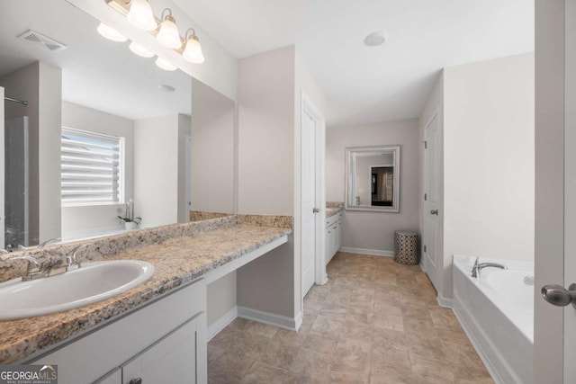 bathroom with vanity, a bath, baseboards, and visible vents