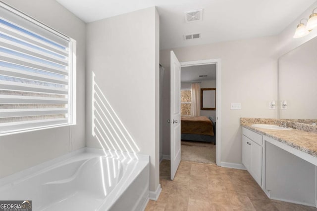 ensuite bathroom with a wealth of natural light, visible vents, and vanity