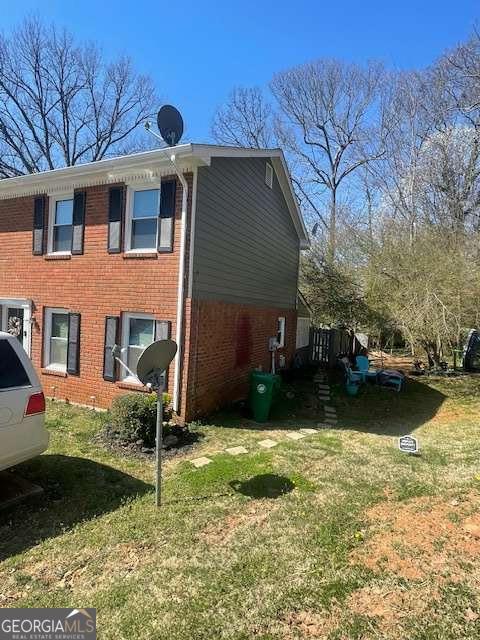 view of side of home featuring a lawn and brick siding