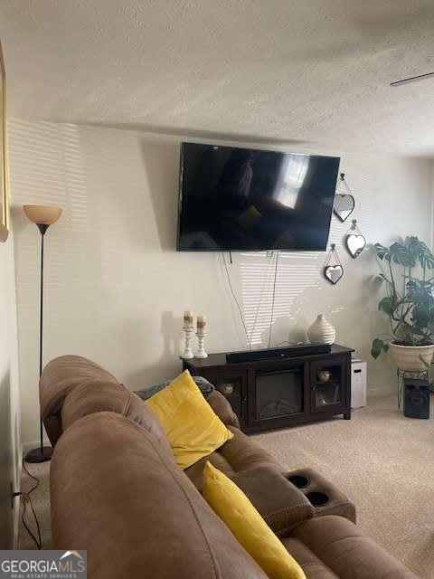 carpeted living room featuring a textured ceiling