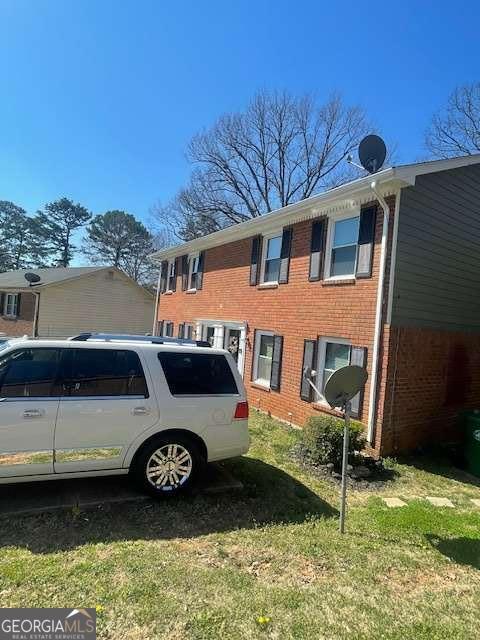 view of side of home with brick siding and a lawn