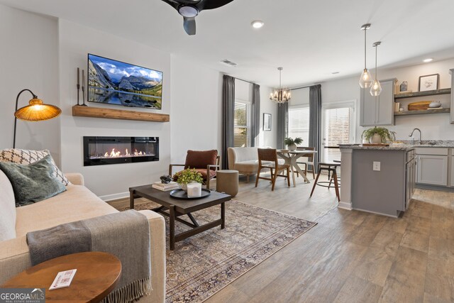 233 Ivey Ter Unit 39, Temple, GA 30179 - living area with a glass covered fireplace, light wood-style floors, a chandelier, recessed lighting, and ceiling fan