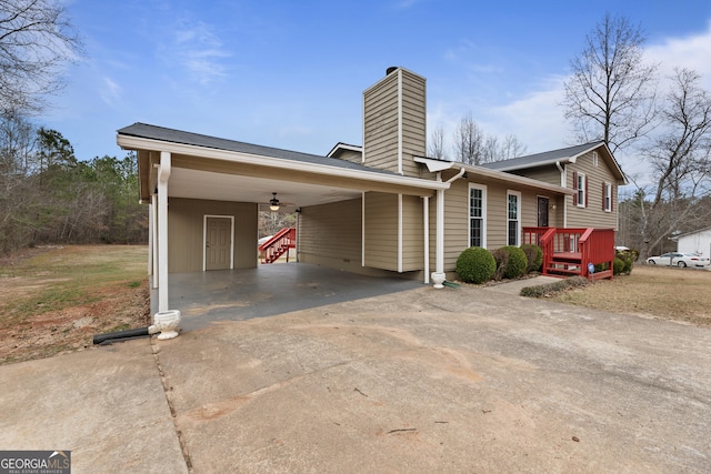 view of front of house featuring an attached carport, driveway, and a chimney